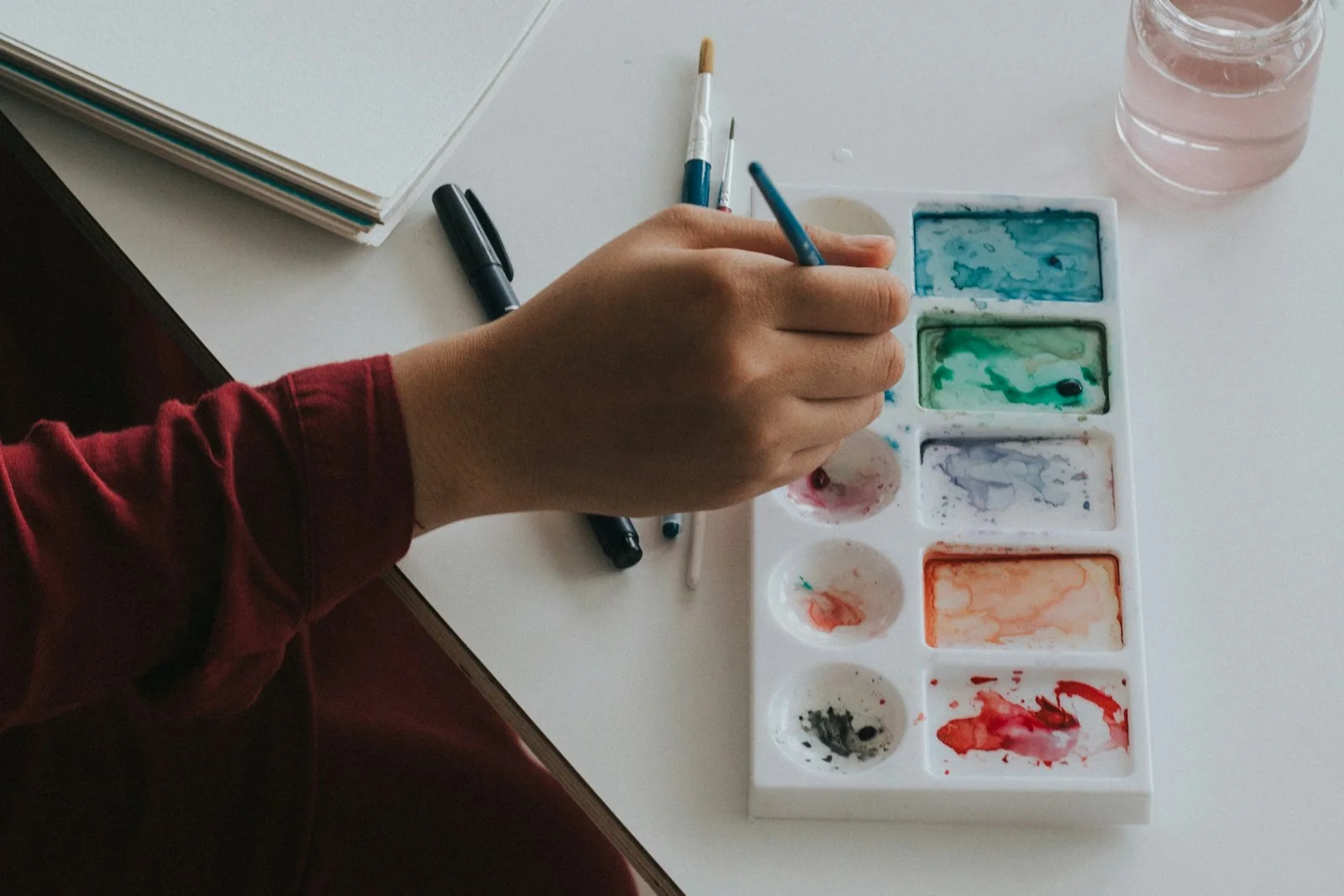 Watercolour painting - palette, brush and sketchbook on a desk